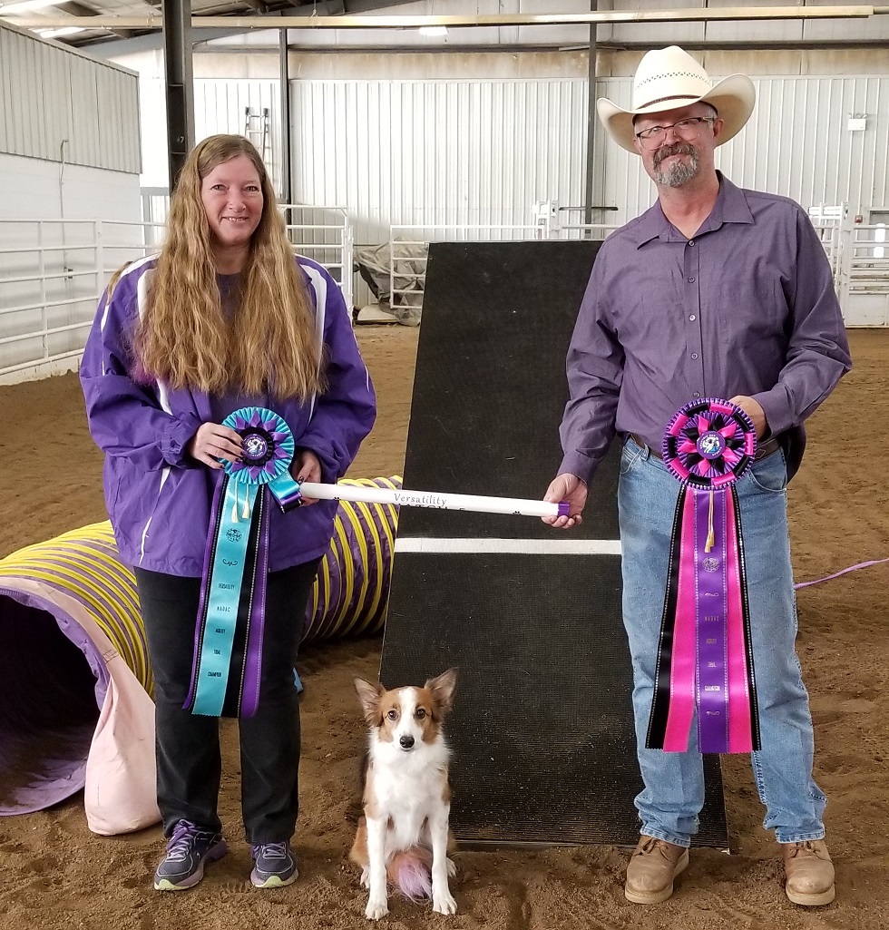 Agility dog, owner, and judge show off Championship ribbons
